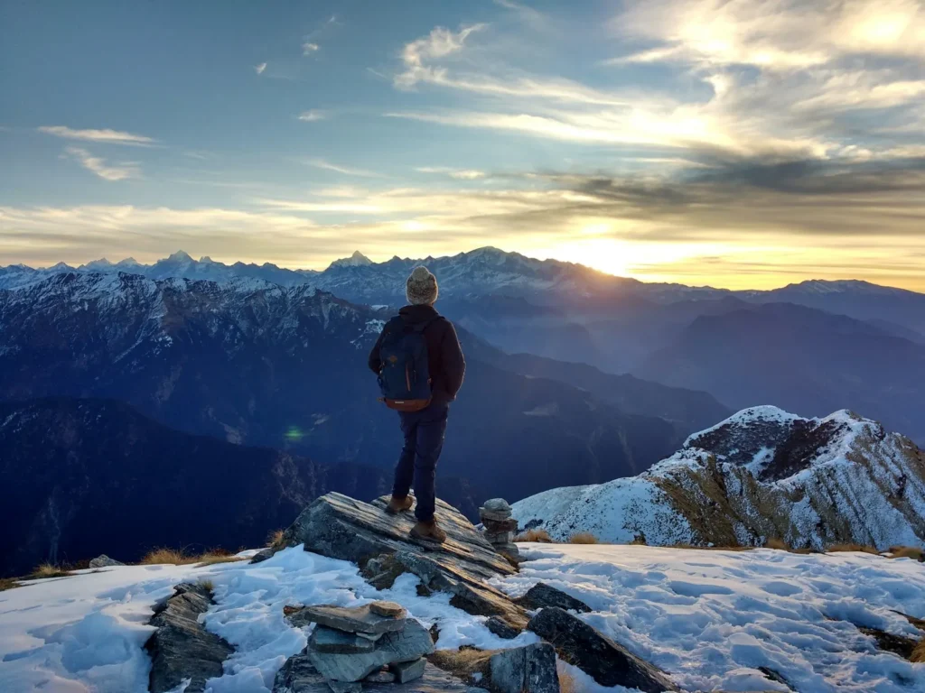 persona en la cima de una montaña al amanecer