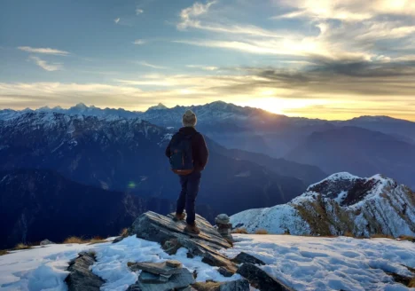 persona en la cima de una montaña al amanecer