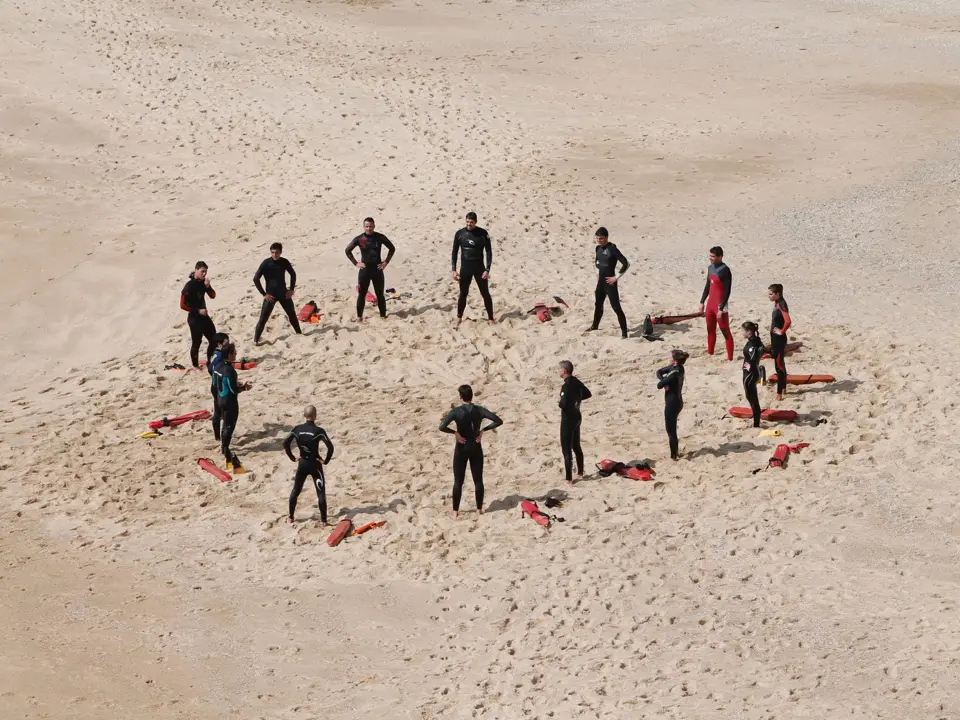 High-Performance Leadership Workshops: team standing in a circle on the beach